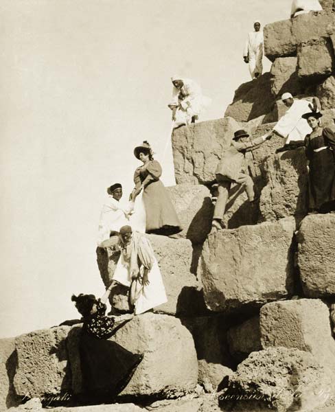 Tourists ascending the pyramids with native guides (b/w photo)  van English Photographer