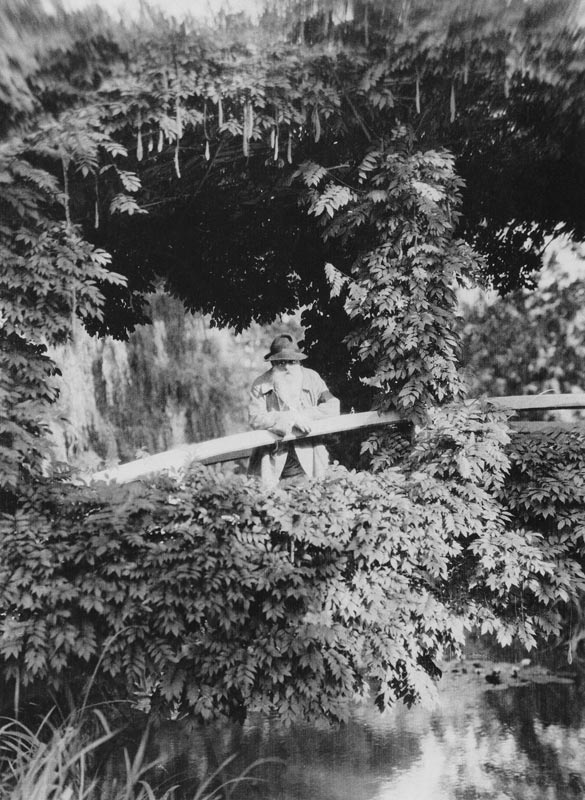 Claude Monet (1841-1926) on the Japanese Bridge in his garden at Giverny, c.1920 (b/w photo)  van French Photographer