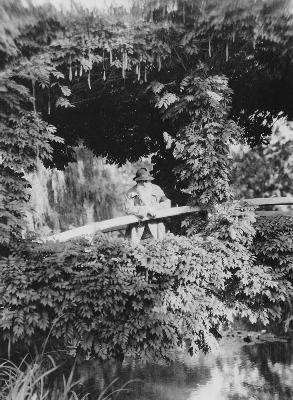 Claude Monet (1841-1926) on the Japanese Bridge in his garden at Giverny, c.1920 (b/w photo) 