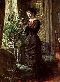 Frau Lisen Samson beim Arrangieren von Blumen vor einem Fenster
