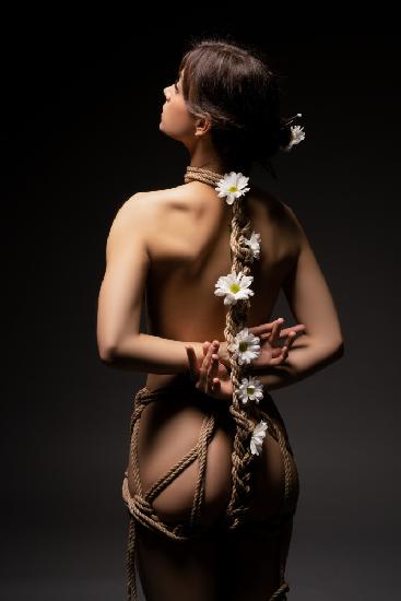 woman tied with ropes and flowers