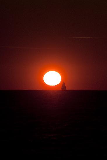 Segelboot bei Sonnenuntergang in Warnemünde van Arno Burgi