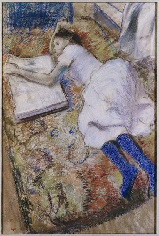 Ein liegendes junges Mädchen, ein Album ansehend van Edgar Degas
