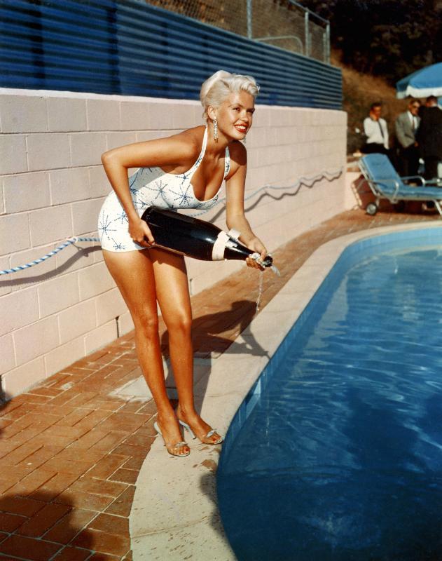 American Actress Jayne Mansfield with a bottle of champagne, near a swimming pool van English Photographer, (20th century)