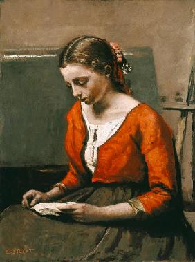 Junge lesende Frau in roter Bluse
