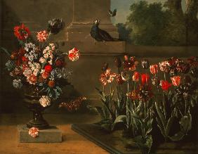 Parterre de tulipes et vase de fleurs au pied d’un mur