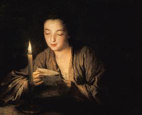 Meisje dat een brief leest bij kaarslicht