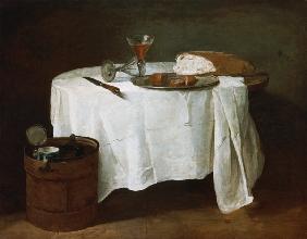 Brot, Wurst und zwei Weingläser auf einem runden Tisch.