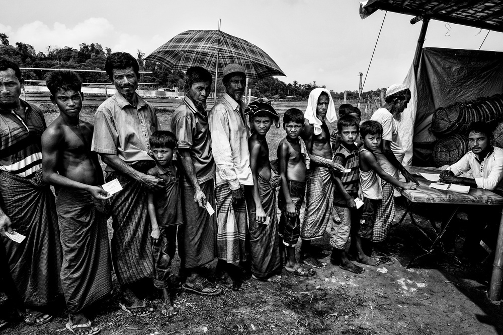 Rohingya refugees queuing to get some items to build their homes. van Joxe Inazio Kuesta Garmendia