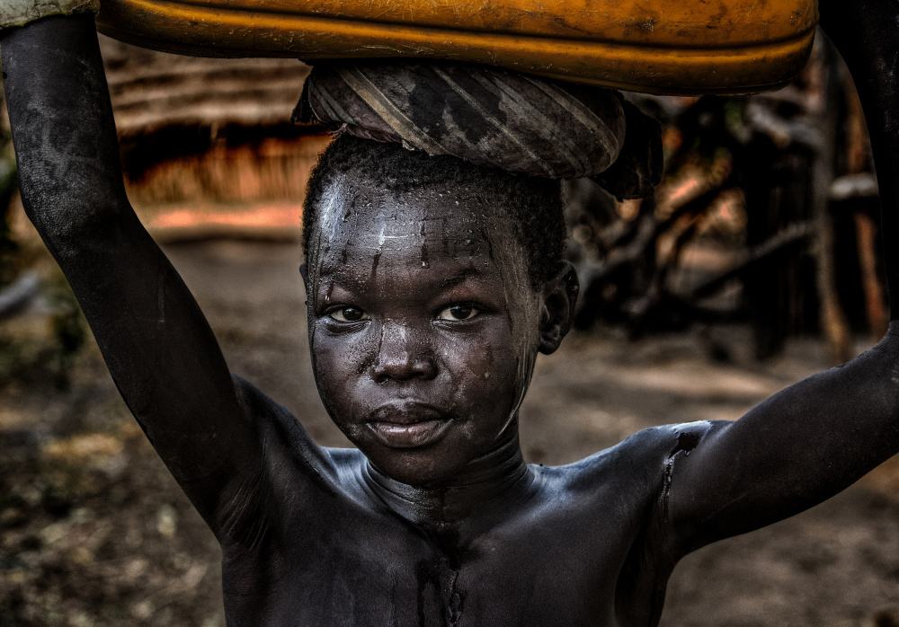 South sudanian child carrying a water containera van Joxe Inazio Kuesta Garmendia