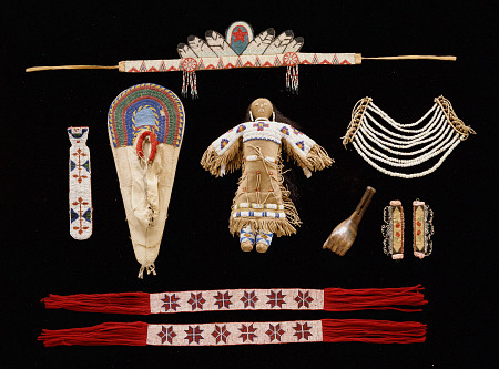 A Collection Of Objects Including Plains Beaded Necktie,  Model Cradleboard, Doll And Neck Ornament van 