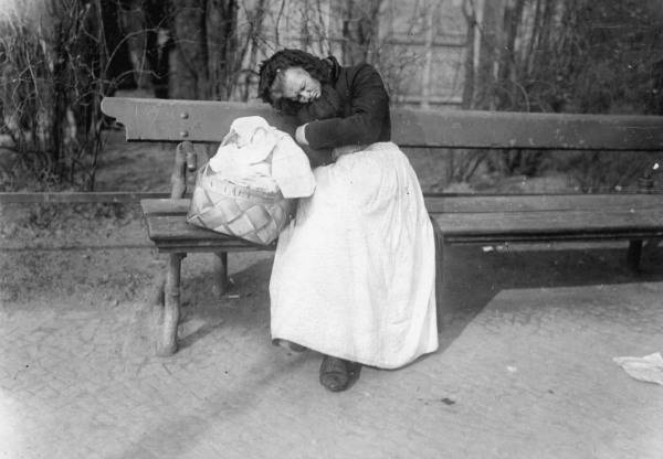 Aeltere Frau auf Berl.Parkbank schlafend van 