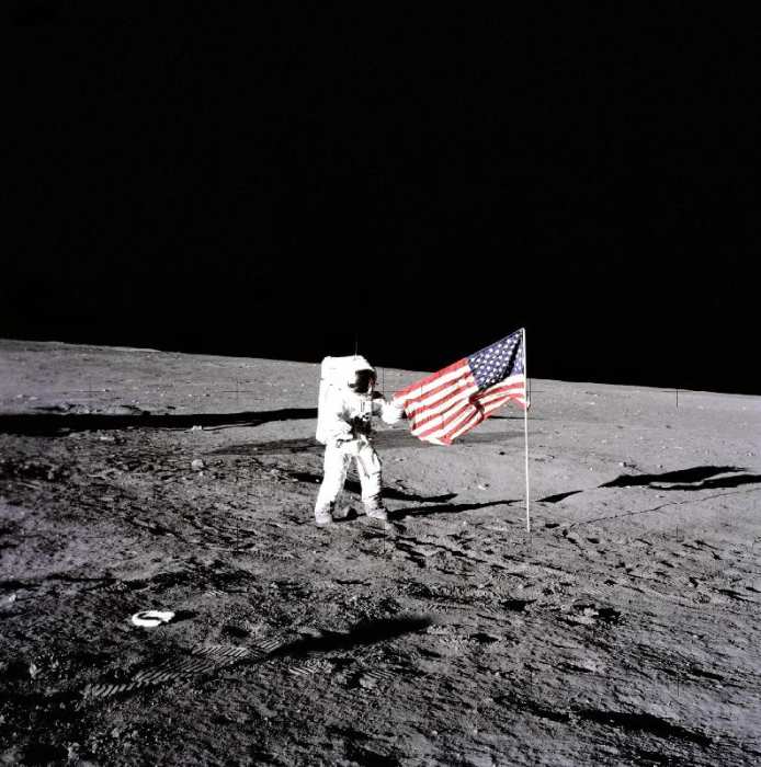 Apollo 12 Astronaut Charles Pete Conrad stands beside the United States flag after is was unfurled o van 