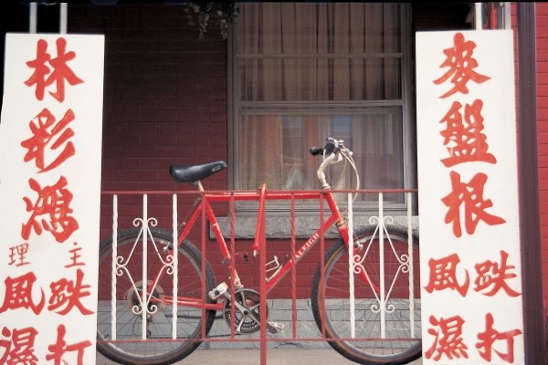 Bicycle at metal bars with Chinese board , Singapore (photo)  van 
