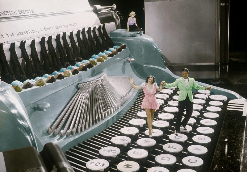 Couple dancing on the key of a giant typewriter, keys are leg of dancers, musical, 30's colourized d van 