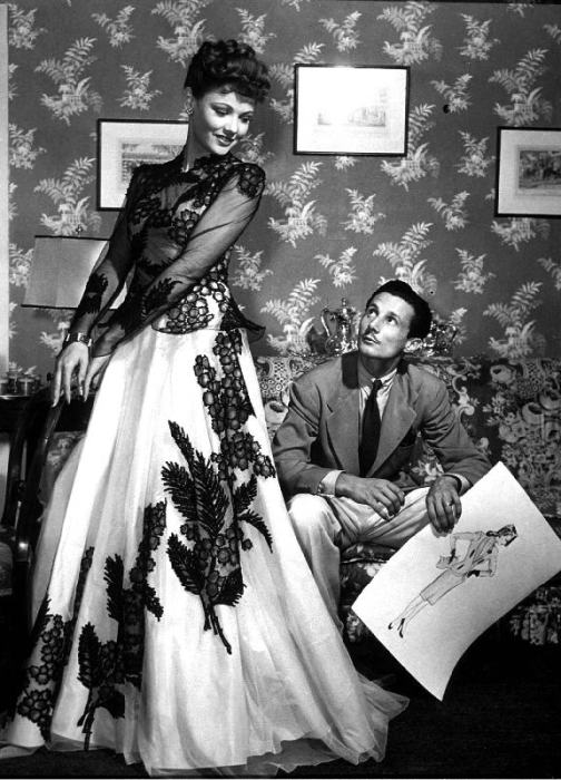 fashion designer Oleg Cassini showing his drawings to Gene Tierney to show her the clothes for film  van 
