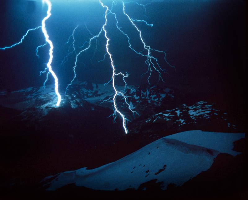 Lightning during a storm over snowy mountains van 