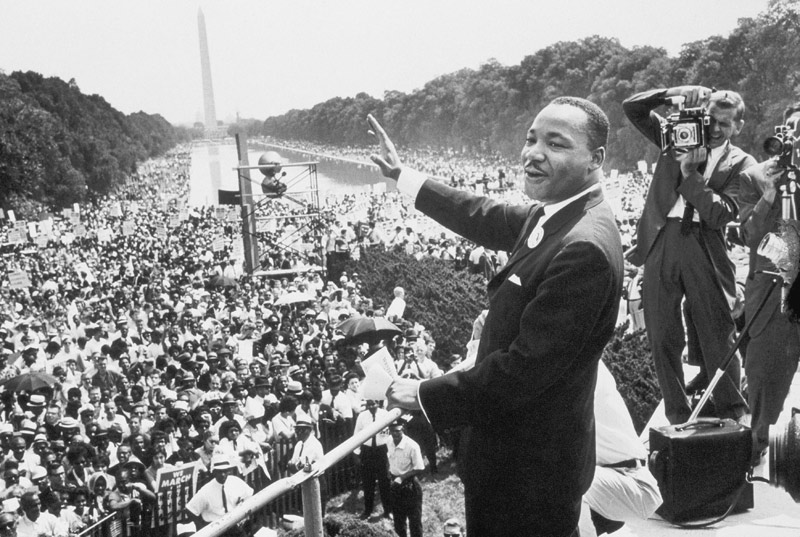 Martin Luther King American priest activist for Civil Right Movement of black Americans saluting the van 