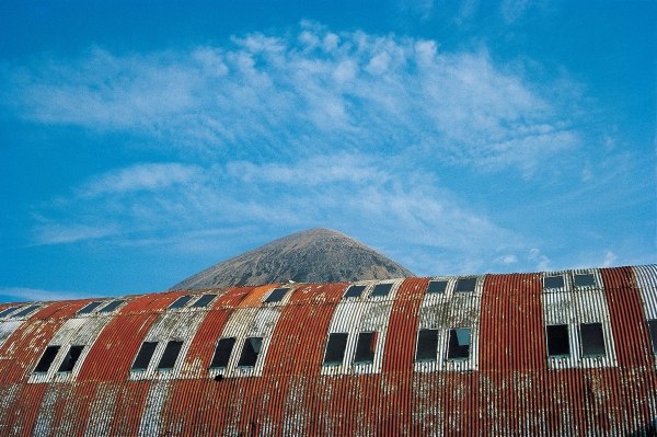 Rusted roof of a deserted warehouse with the breast of a mountain (photo)  van 