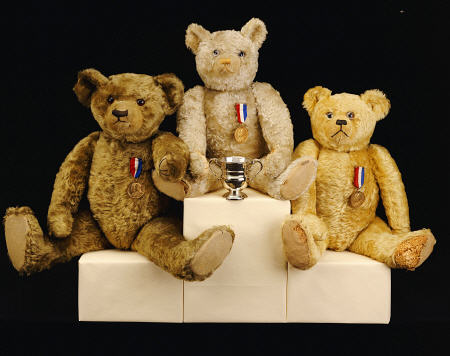 Three Farnell Teddy Bears On A Medal Winners Plinth van 