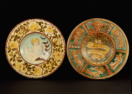 Two Della Robbia Wall Chargers, One Depicting A Putto Riding A Crescent Moon, The Other Designed By van 
