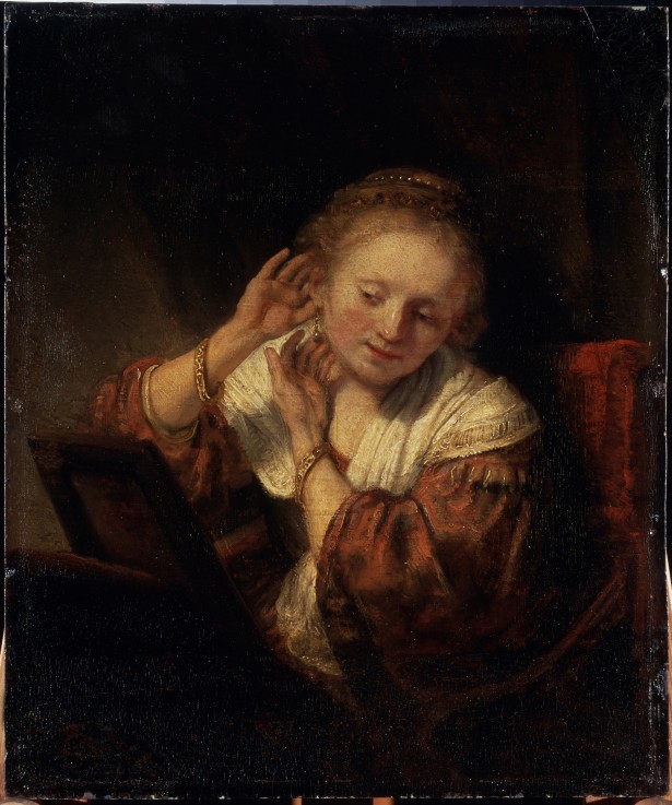 Young Woman trying on Earrings van Rembrandt van Rijn