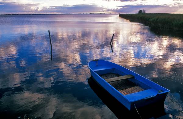 Blaues Boot am Seeufer mit Wolkenstimmung van Robert Kalb