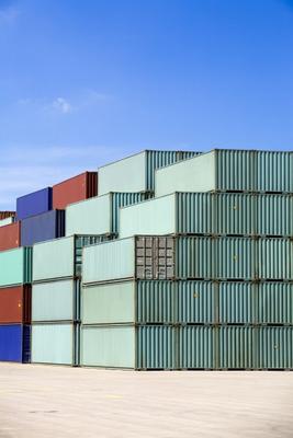 shipping containers against blue sky van Sascha Burkard