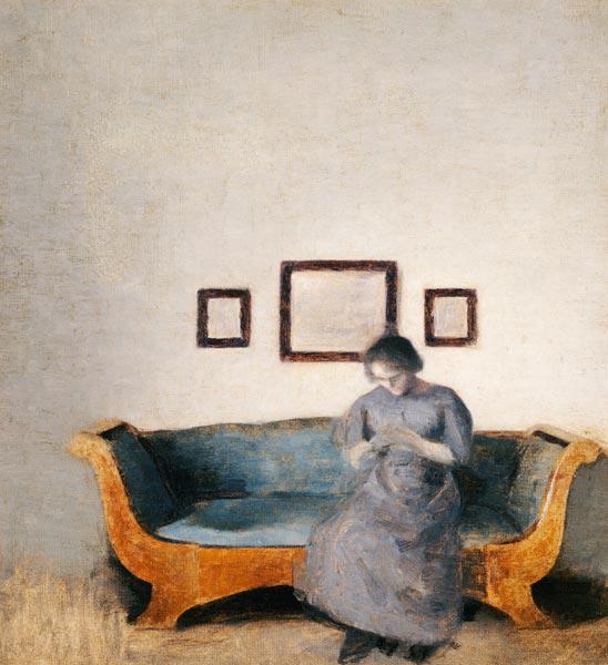 Ida Hammershoi auf dem Sofa sitzend.